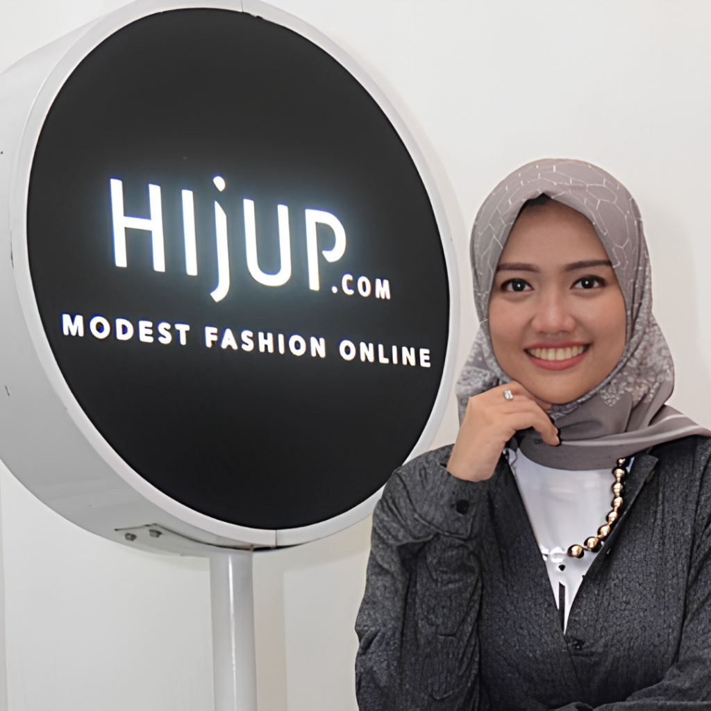Diajeng Lestari, founder of HijUp, beside the HijUp.com modest-fashion sign, illustrating a business formalised from an informal start in Indonesia.