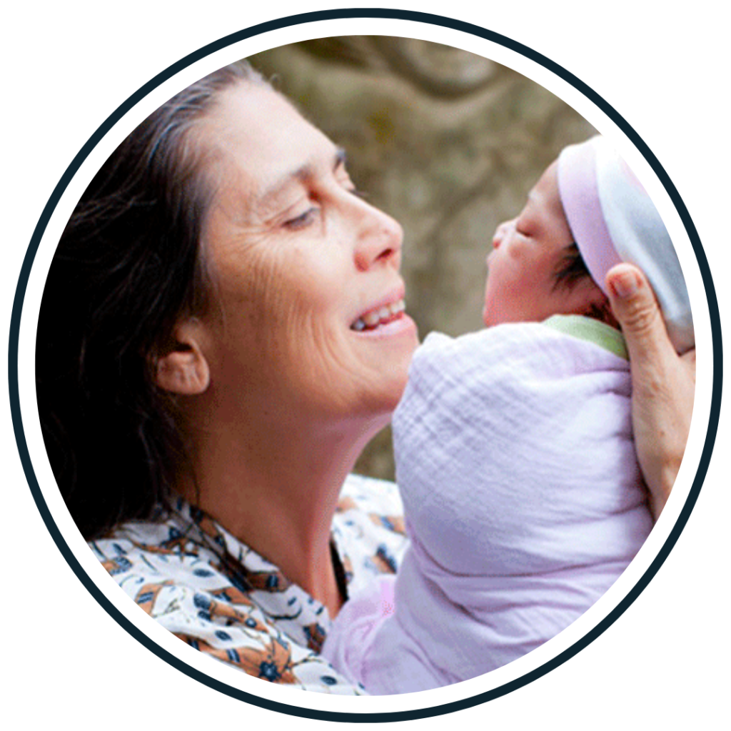 Robin Lim, founder of Yayasan Bumi Sehat, with a newborn, illustrating a maternal-health mission run as a foundation in Indonesia. Confirm this is Robin Lim rather than a Bumi Sehat mother.