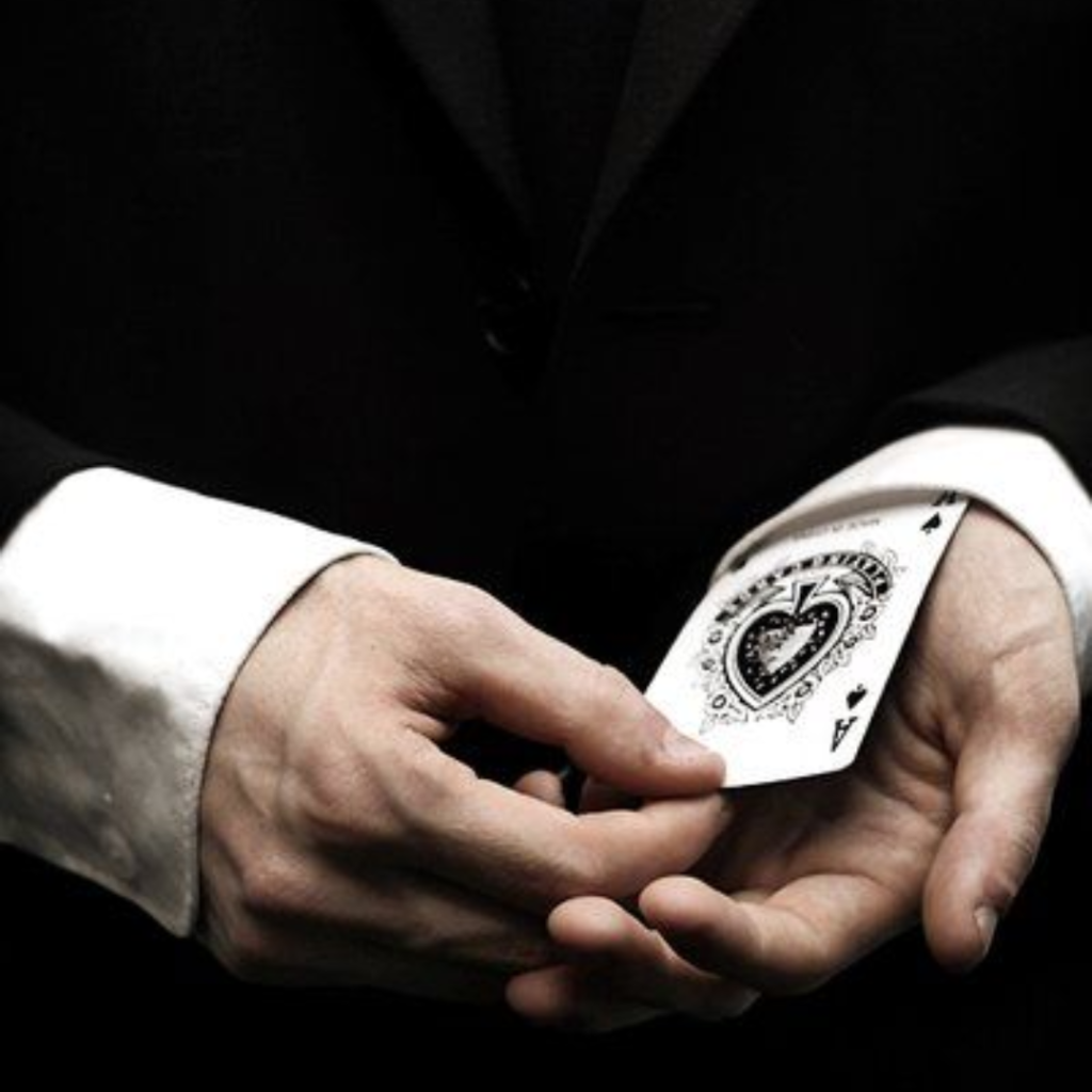 Hands producing a concealed ace in a card trick, illustrating the sleight of hand of a nominee shortcut used to disguise foreign land ownership in Bali.
