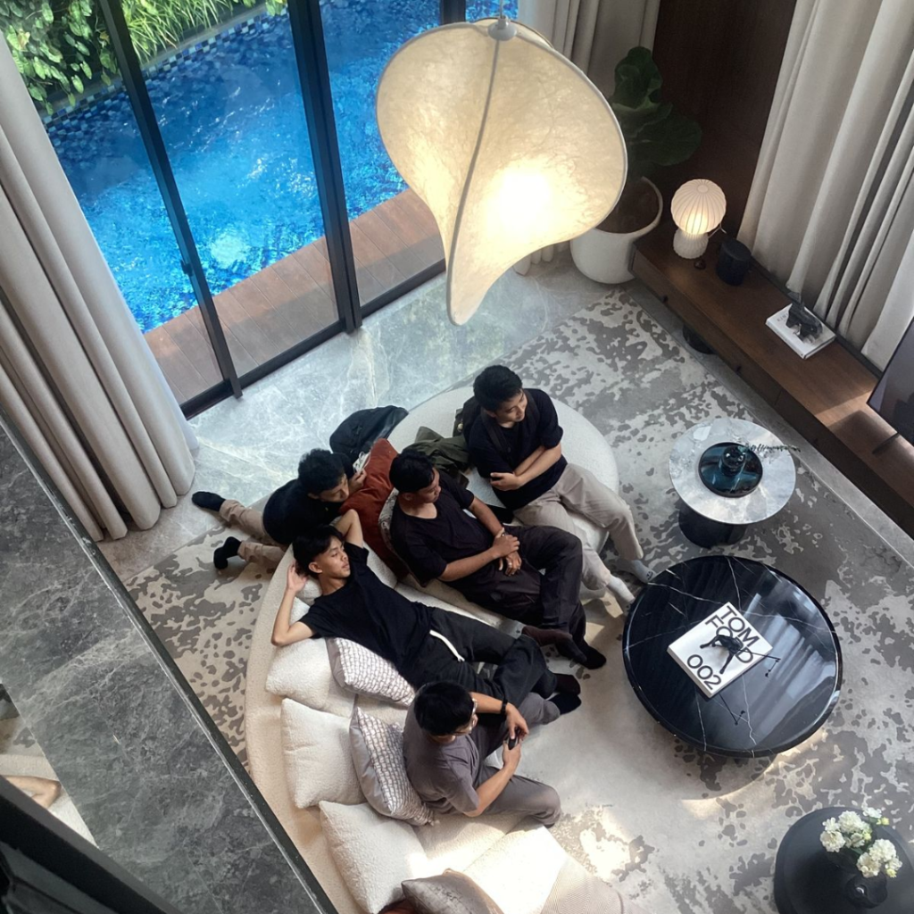 A young family relaxing together in a modern Bali villa with a pool, illustrating a family office in Bali